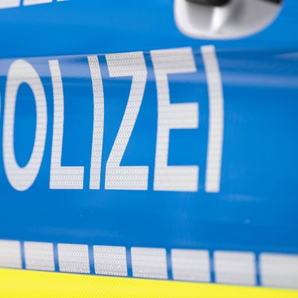 Das Foto zeigt den Schriftzug „Polizei“ auf einem Streifenwagen.