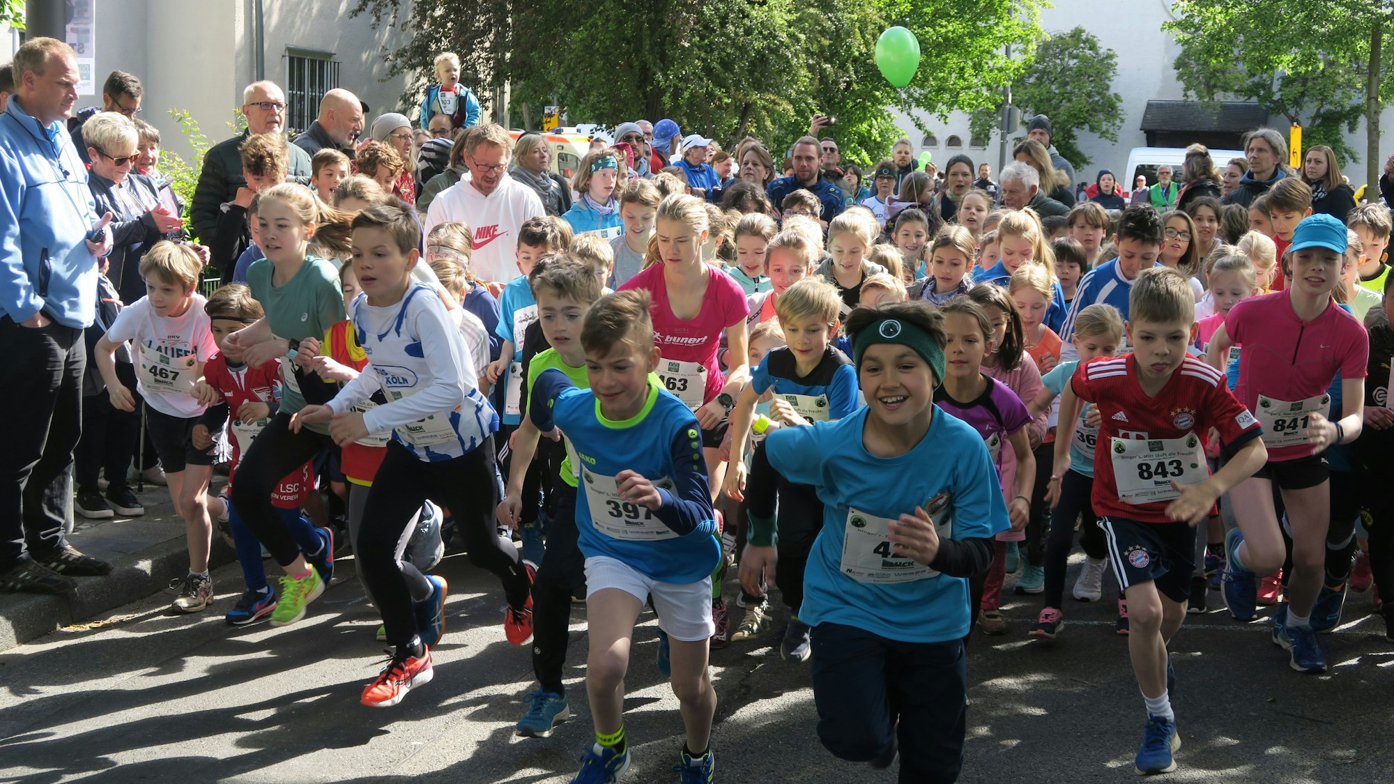 Viele Jungen und Mädchen starten zu einem Lauf.