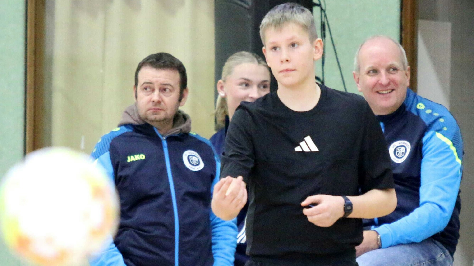 Turnierleiter Sascha Wagner und weitere Verantwortliche des VfL Kommern beobachten das Geschehen, im Vordergrund steht ein Schiedsrichter.