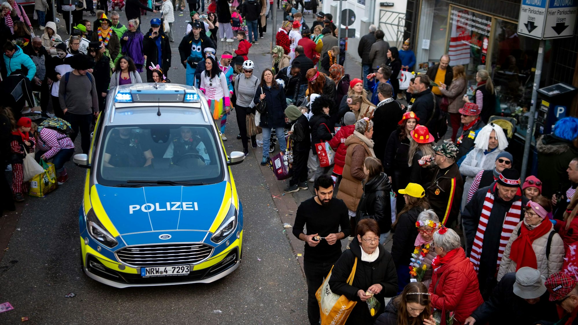 Das Bild zeigt einen Streifenwagen, der hinter dem Prinzenwagen in Euskirchen fährt.