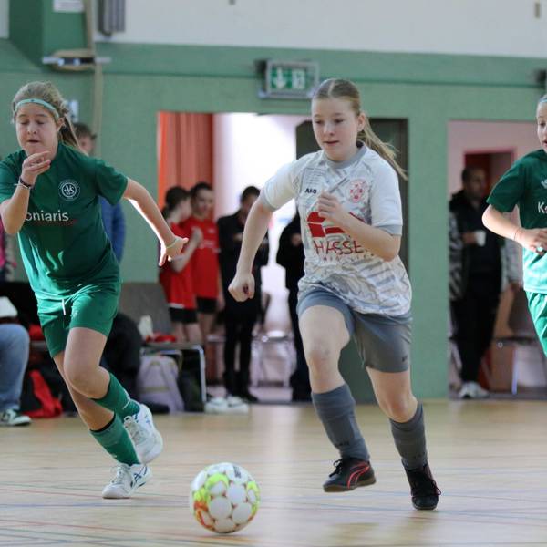 Eine Zülpicher Spielerin führt den Ball und wird von zwei Gegenspielerinnen flankiert.