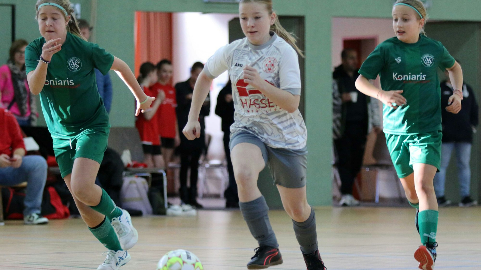 Eine Zülpicher Spielerin führt den Ball und wird von zwei Gegenspielerinnen flankiert.