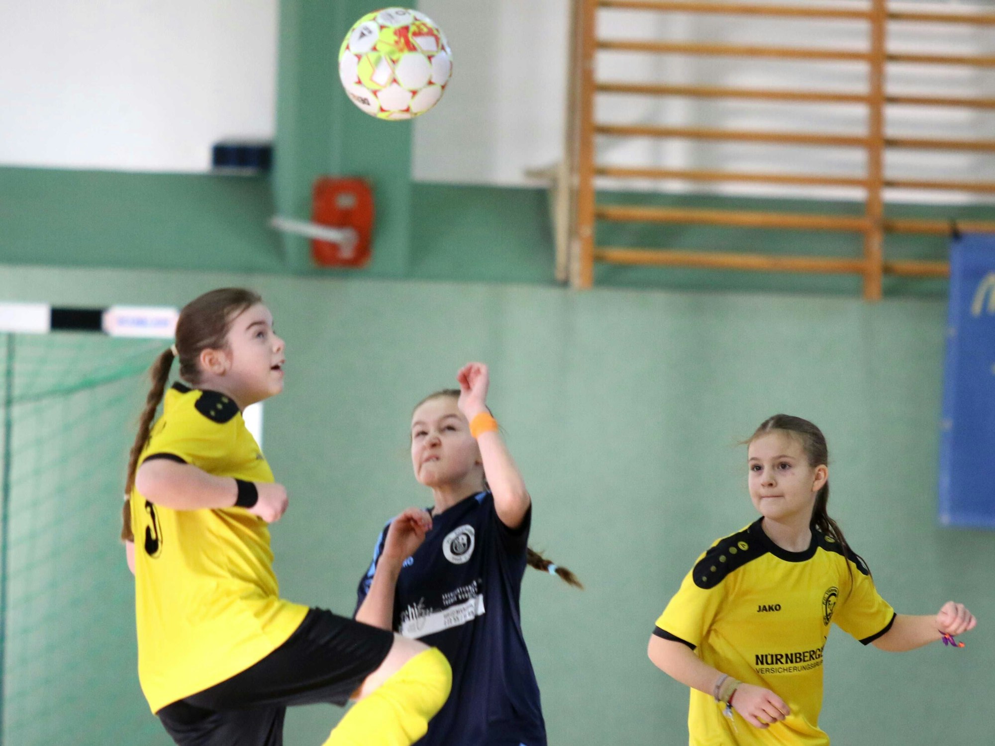Mit zusammengekniffenem Augen schauen zwei Spielerinnen auf den Ball, der sich über ihnen befindet.