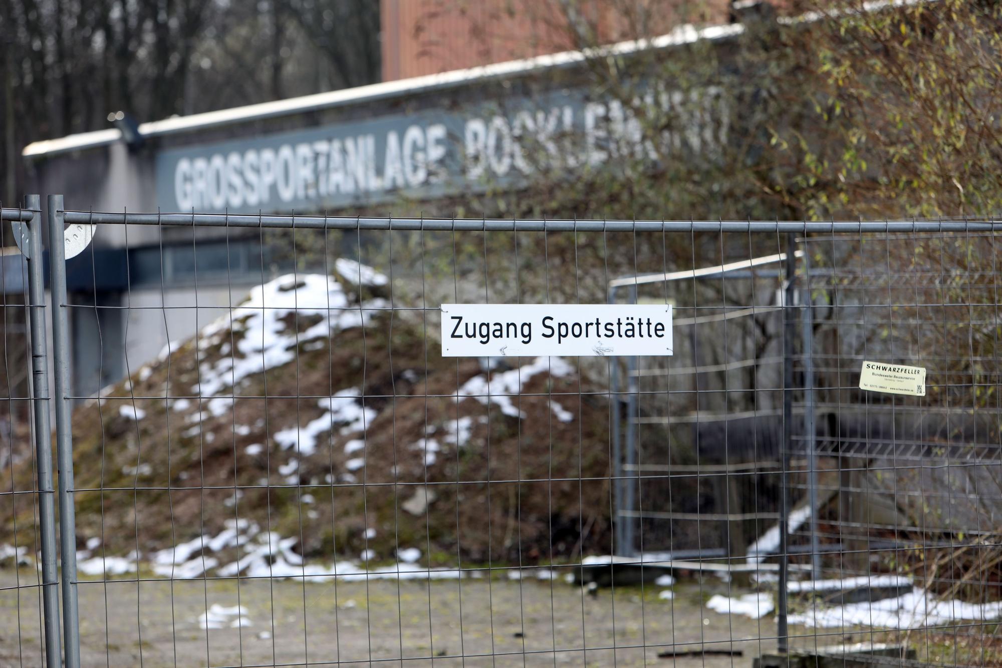 Außenansicht der Bezirkssportanlage Bocklemünd mit Blick auf einen Bauzaun.