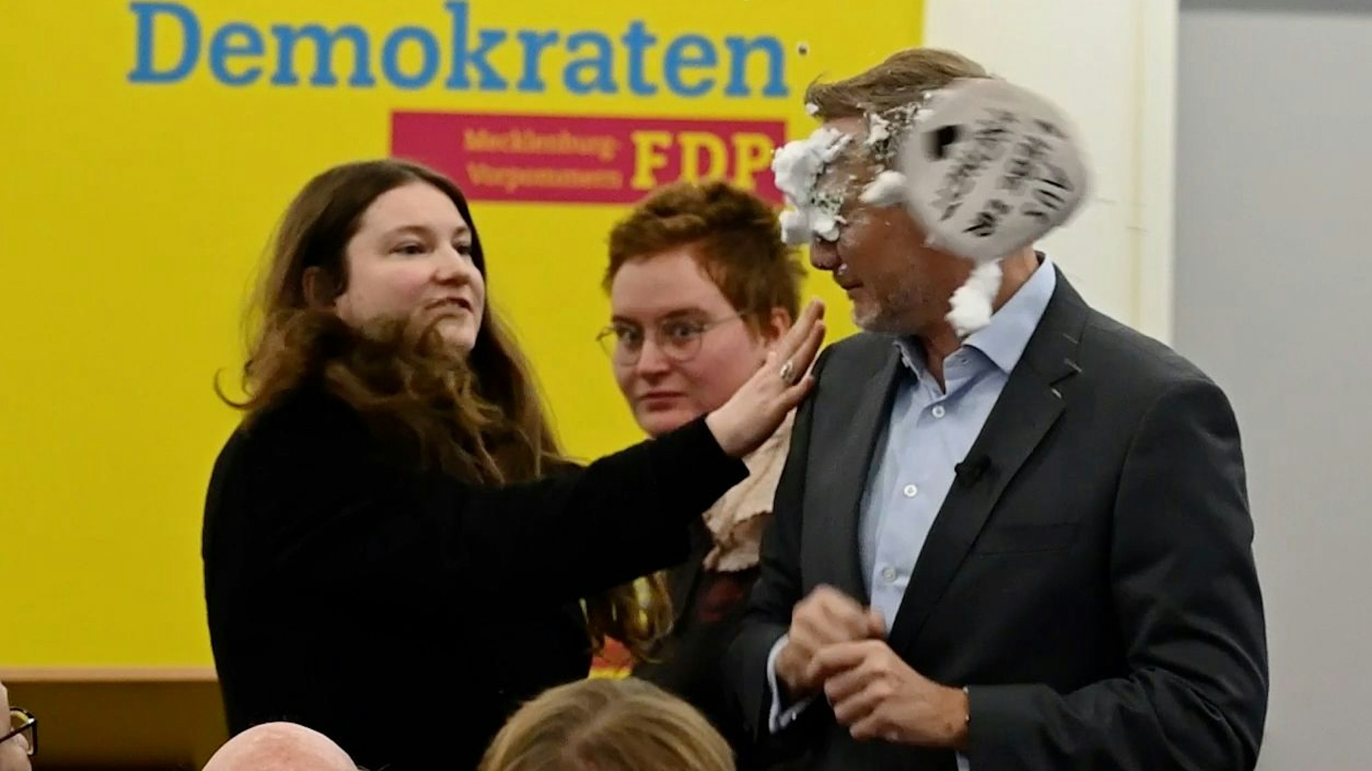 Mecklenburg-Vorpommern, Greifswald: Der FDP-Vorsitzende Christian Lindner bekommt bei einem Wahlkampfauftritt in Greifswald von der Linke-Lokalpolitikerin Christiane Kiesow (l) Schaum ins Gesicht geworfen.