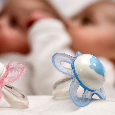 Ein rosa und ein blauer Schnuller.