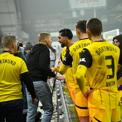 14.01.2025, Schleswig-Holstein, Kiel: Fußball: Bundesliga, Holstein Kiel - Borussia Dortmund, 17. Spieltag, Holstein-Stadion. Spieler Emre Can diskutiert mit einem Dortmund-Fan nach dem 4:2-Sieg am Spielfeldrand. Foto: Gregor Fischer/dpa - WICHTIGER HINWEIS: Gemäß den Vorgaben der DFL Deutsche Fußball Liga bzw. des DFB Deutscher Fußball-Bund ist es untersagt, in dem Stadion und/oder vom Spiel angefertigte Fotoaufnahmen in Form von Sequenzbildern und/oder videoähnlichen Fotostrecken zu verwerten bzw. verwerten zu lassen. +++ dpa-Bildfunk +++