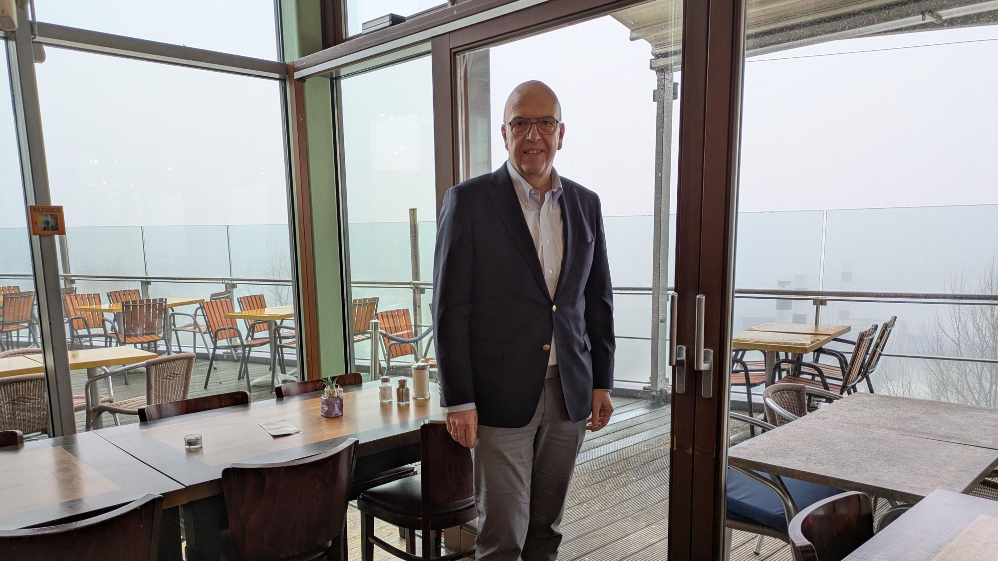 Siegmar Heß steht in einem Gastraum des Cafés Wacht am Rhein