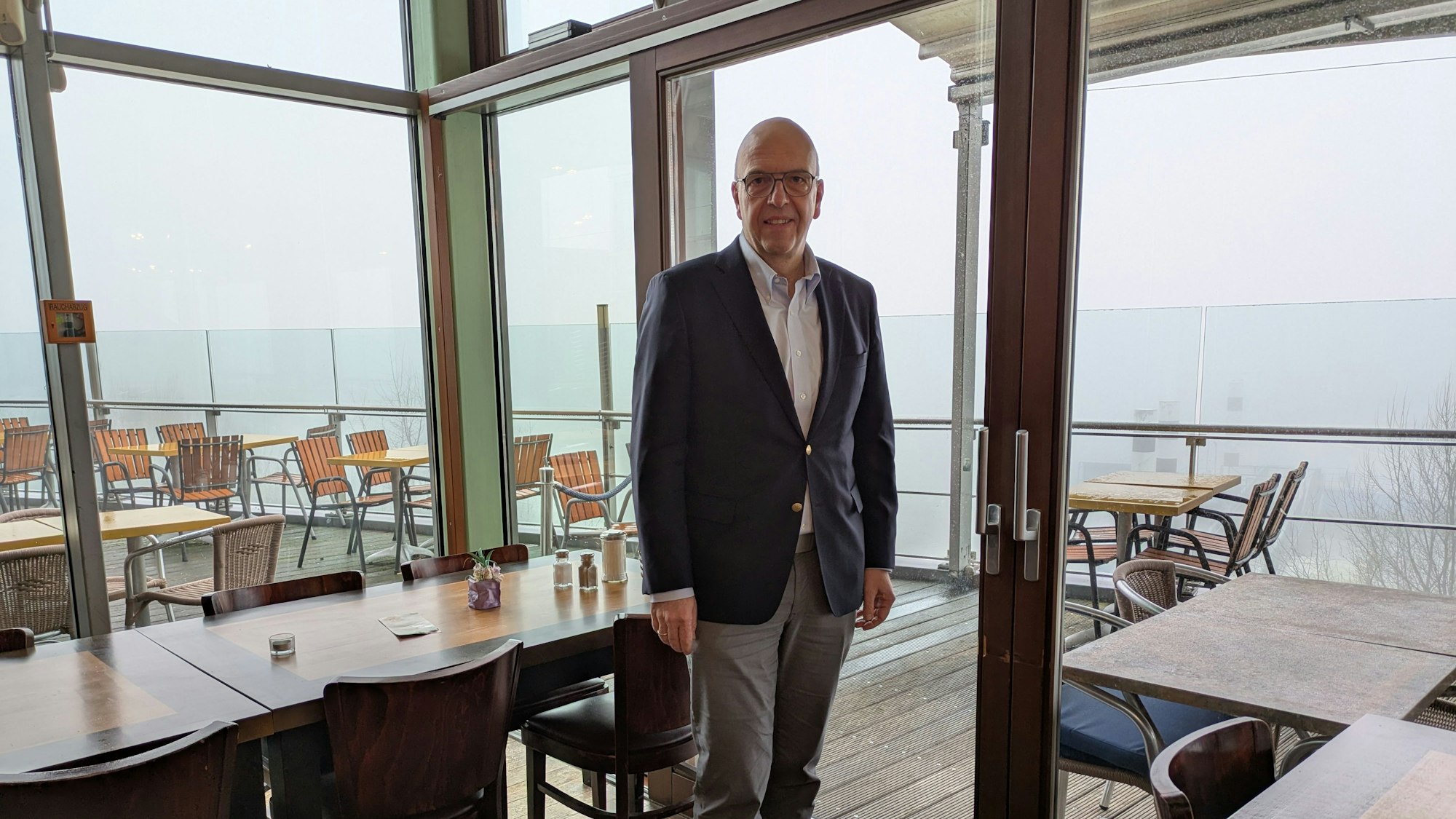 Siegmar Heß steht in einem Gastraum des Cafés Wacht am Rhein