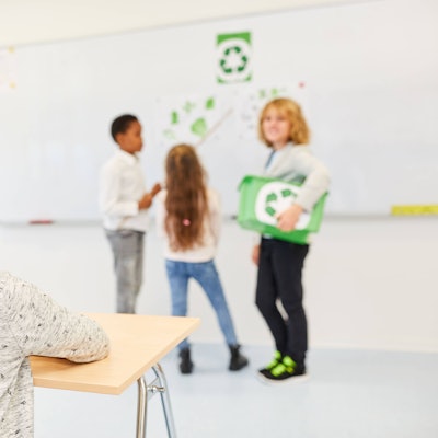 Schüler*innen in der Grundschule halten ein Referat über Recycling und Umweltschutz.