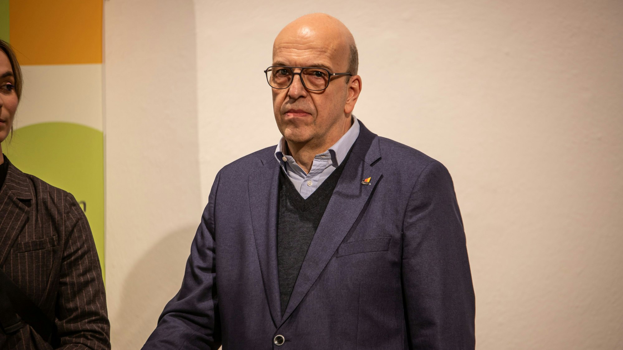 Ein Mann in einem blauen Jackett blickt in die Kamera.