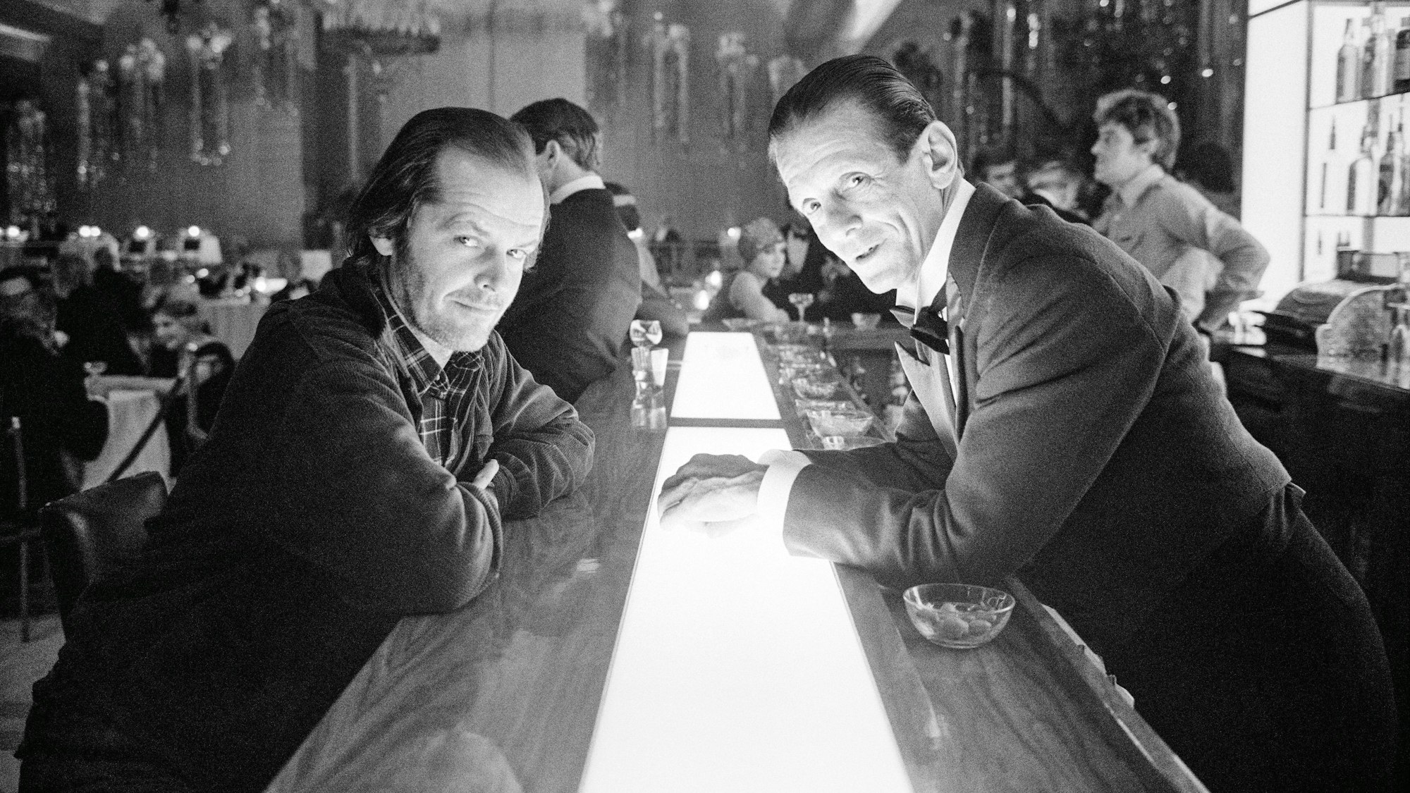 Jack Nicholson und Joe Turkel lehnen sich gegenüber an der Bar im Ballsaal-Set von "The Shining"
