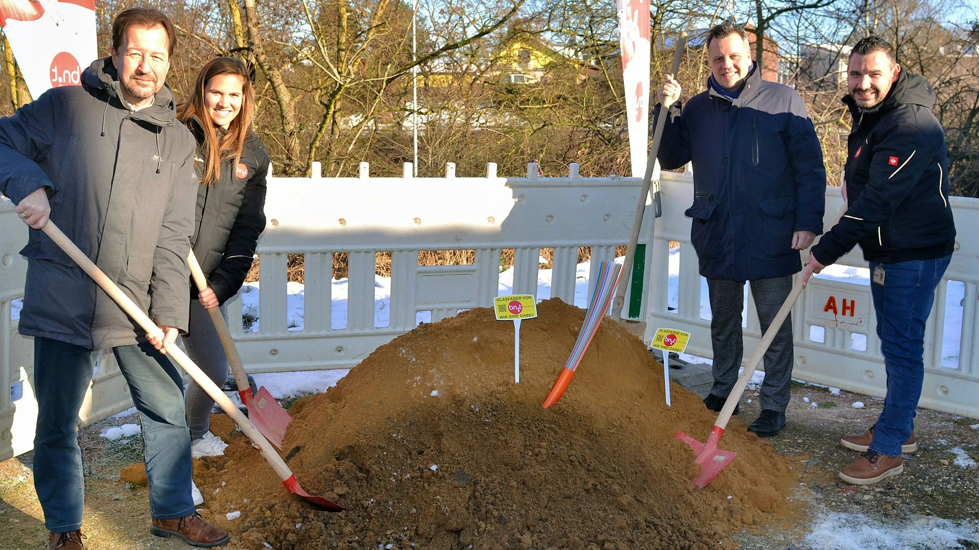 Elmar Müller, Barbara Gardner, Sacha Reichelt und Nikolaos Pantios stehen mit Schaufel an einem Hügel ausgehobener Erde.
