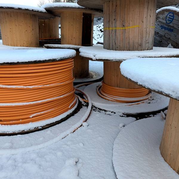 Kabeltrommeln mit Glasfaserleitungen im Schnee.