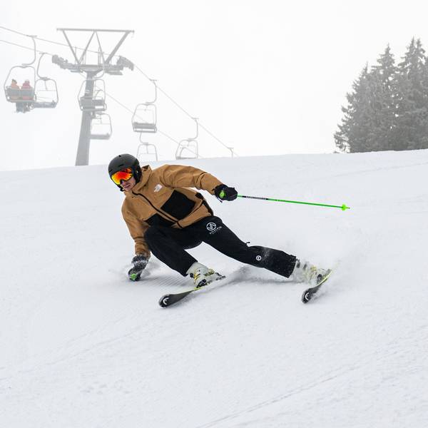Ein Skifahrer fährt eine Piste hinunter.