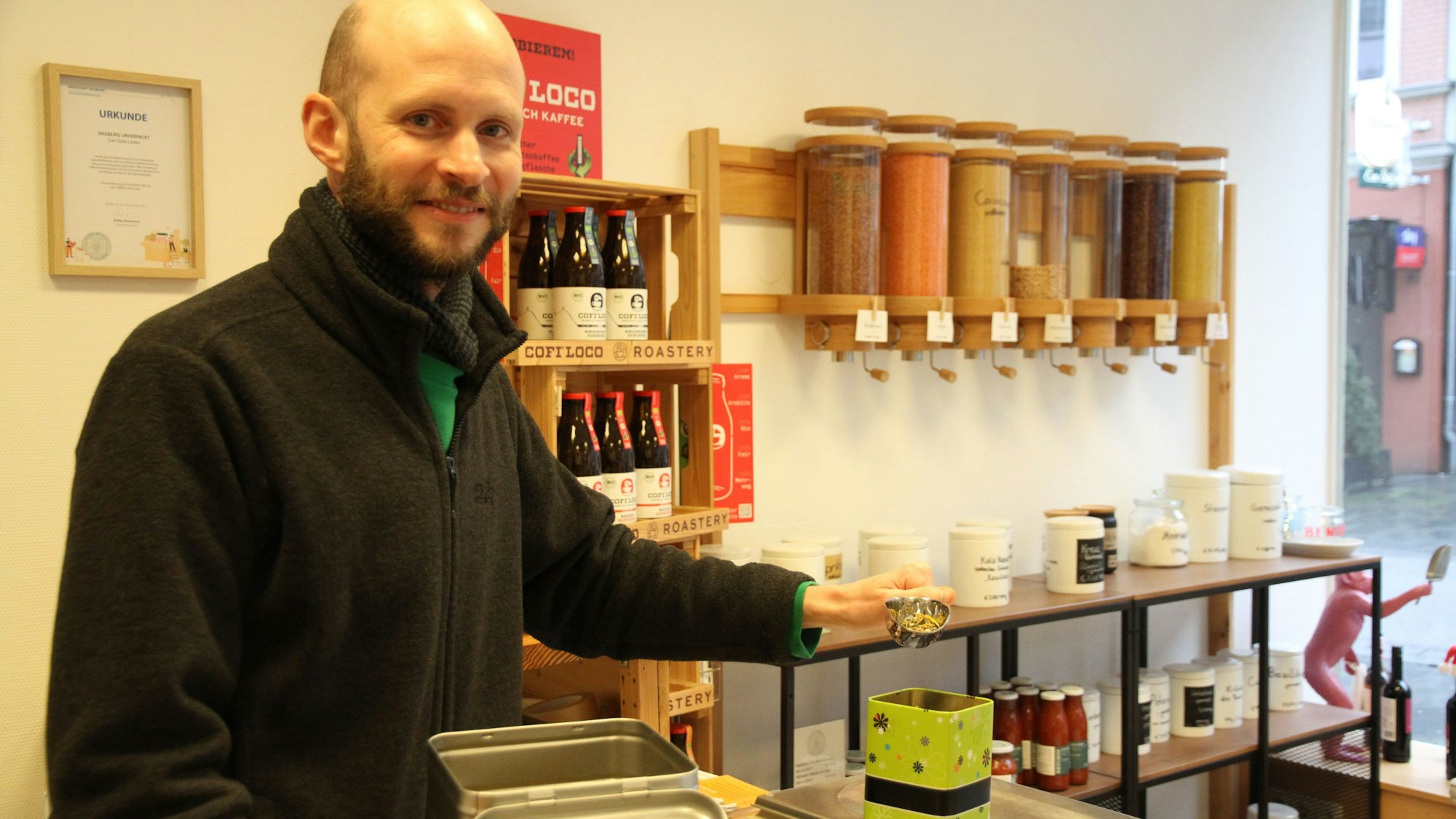 Ein Mann füllt Tee aus einer großen Dose um.