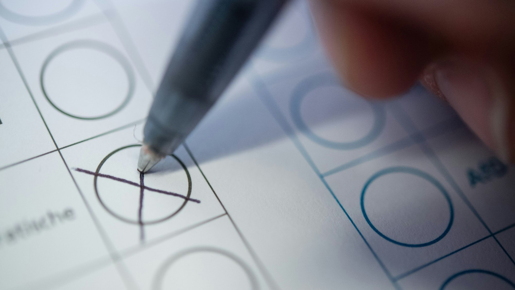 Eine Frau macht ein Kreuz auf einem Wahlzettel.