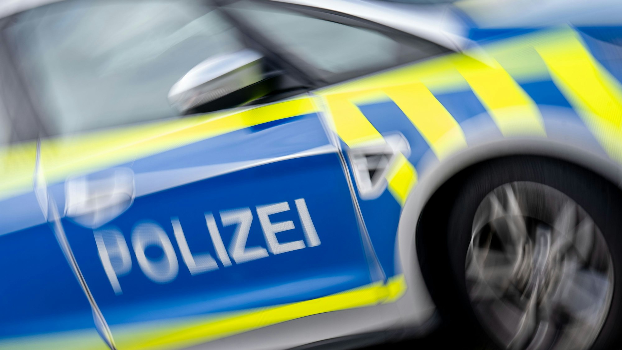 Das Foto zeigt einen Streifenwagen mit der Aufschrift „Polizei“ auf der Tür.