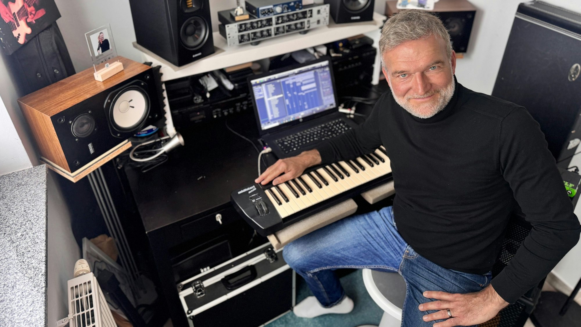 Zu sehen ist ein Mann an einem Keyboard und einer Musikanlage.