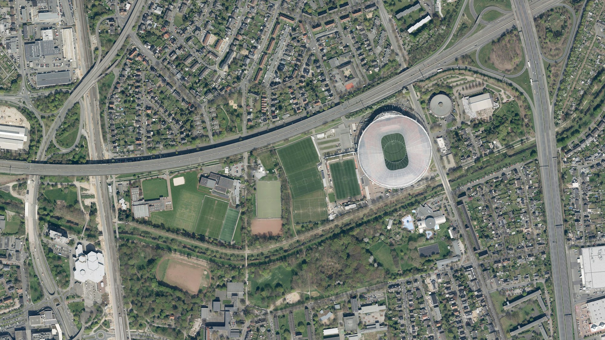 Der Sportpark mit dem Stadion, den Bayer-04-Trainingsplätzen, dem Stadtpark im Süden und dem SC-Leverkusen-Platz liegt mitten in der Innenstadt. Den Sportpark und den Stadtpark trennt die Dhünn. Mitte links unten liegt der Aschenplatz, auf den der SC Leverkusen umziehen soll.