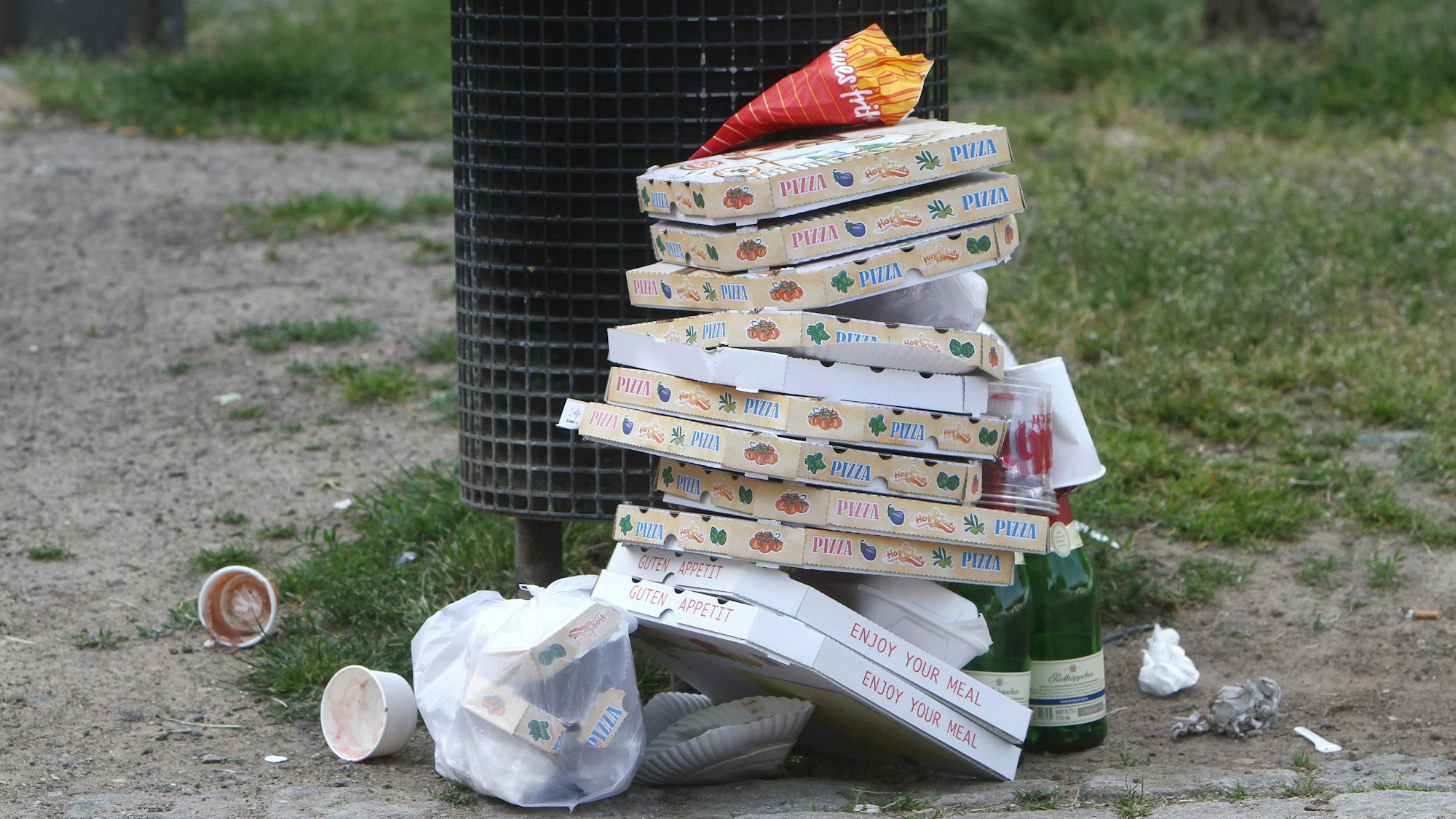 Pizza Schachteln stapeln sich nach einem Außer Haus Verzehr neben geleerten Sektflaschen vor einem überfüllten Mülleimer in der Altstadt von Köln, Nordrhein Westfalen, Deutschland *** Pizza boxes pile up next to empty champagne bottles in front of an overfilled garbage can in the old town of Cologne, North Rhine-Westphalia, Germany