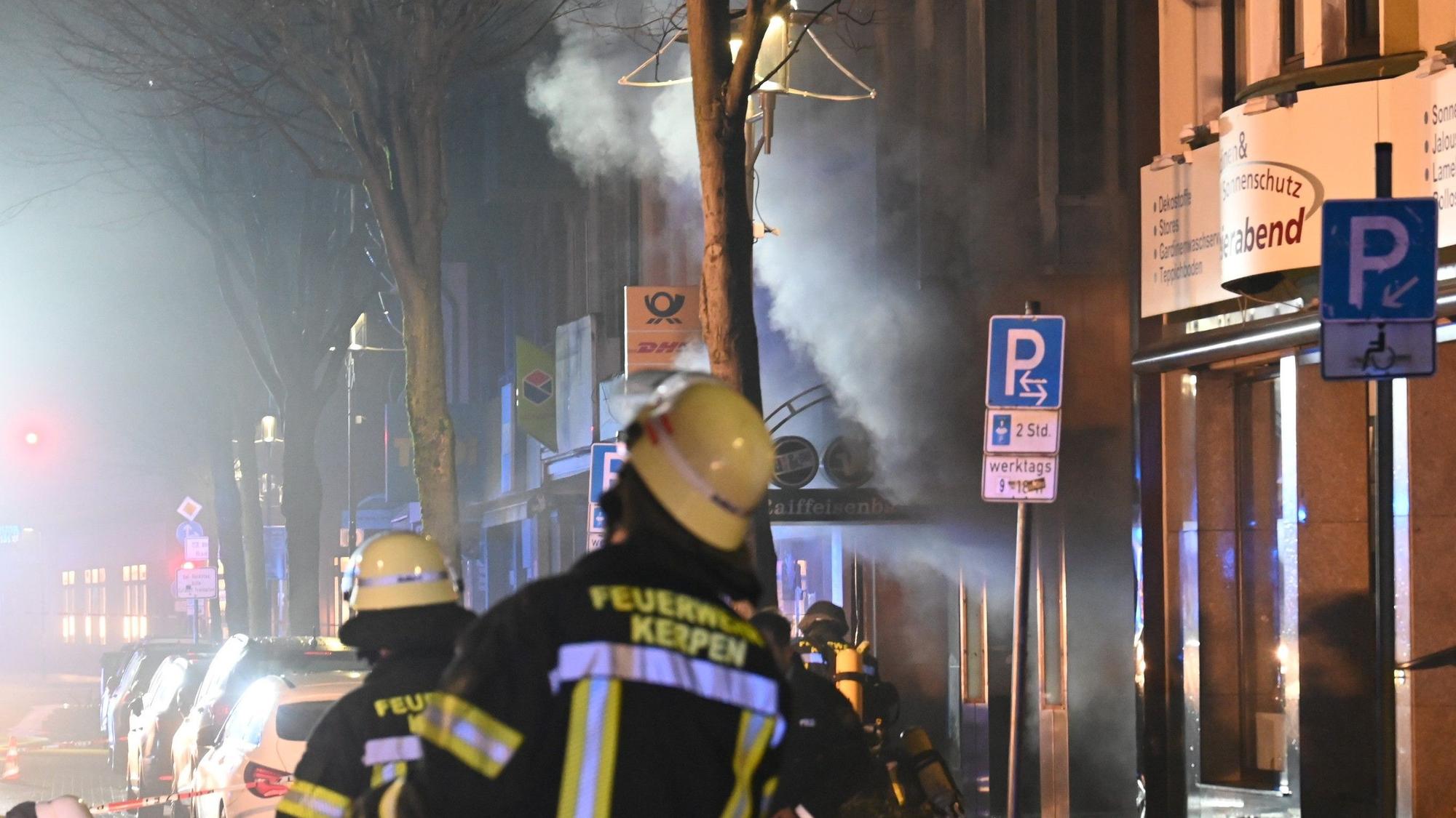 Das Bild zeigt Feuerwehrleute vor der qualmenden Filiale der Volksbank.