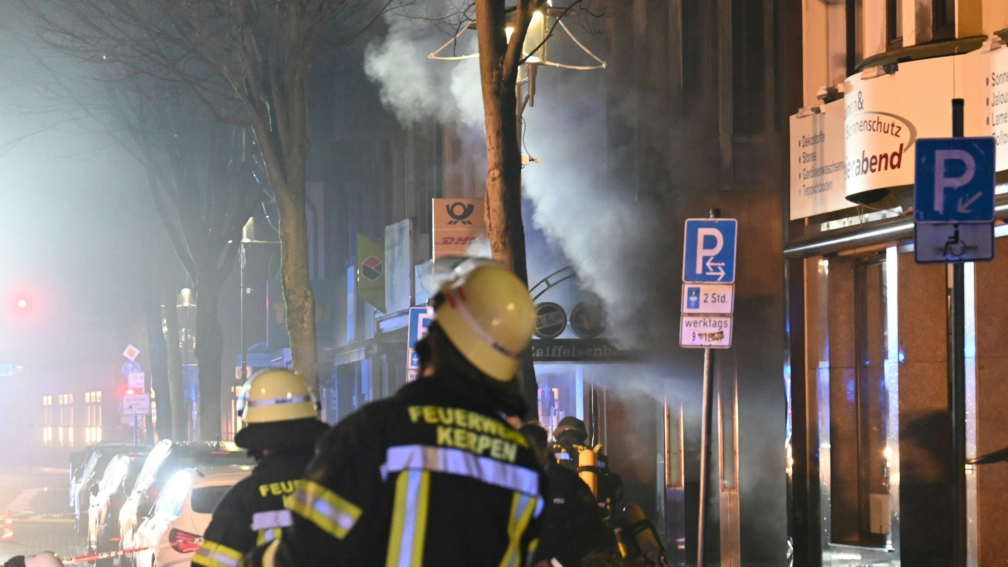 Das Bild zeigt Feuerwehrleute vor der qualmenden Filiale der Volksbank.