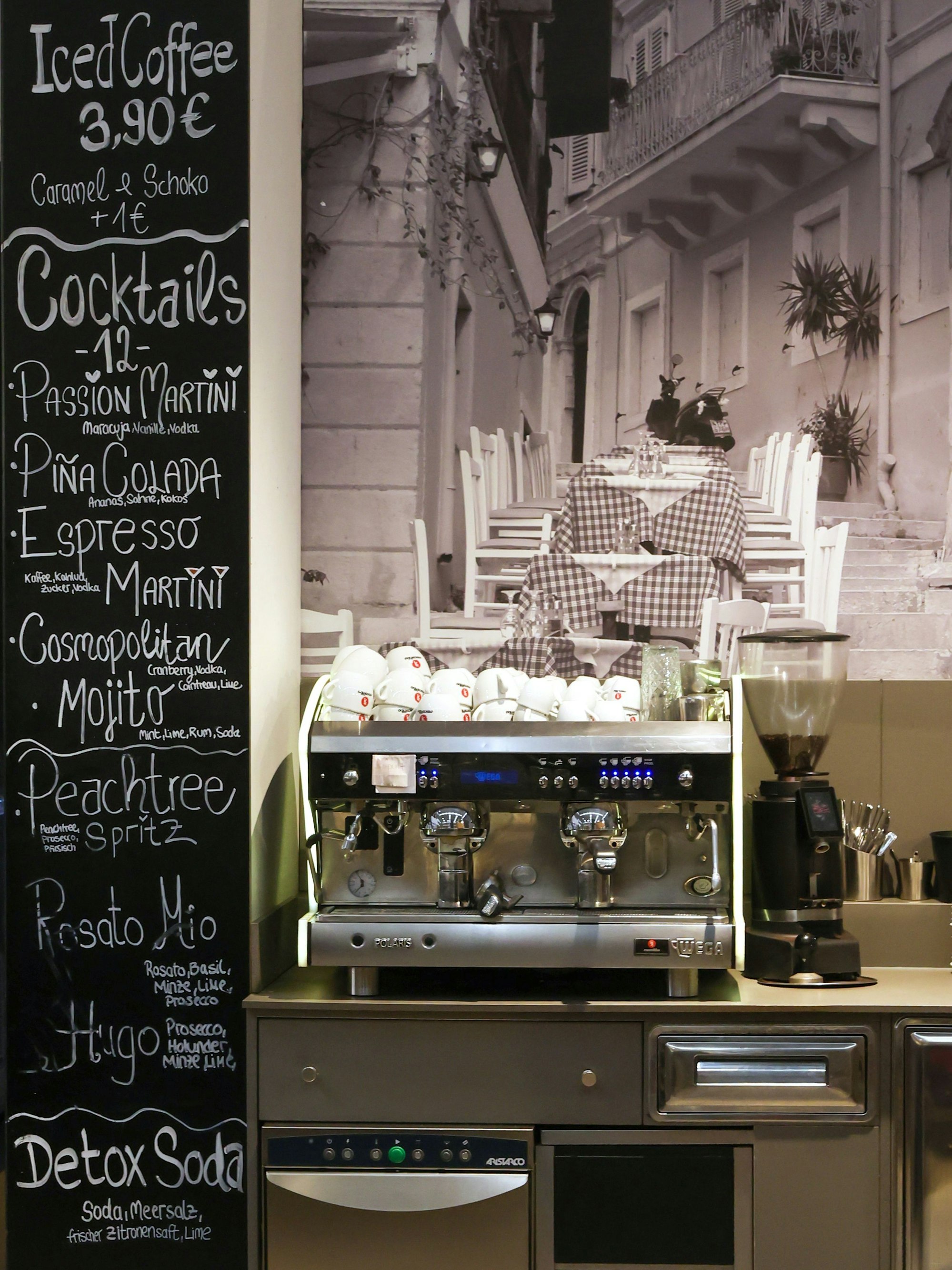 Kaffeemaschine und eine Tafel mit Getränkeangeboten sind zu sehen.