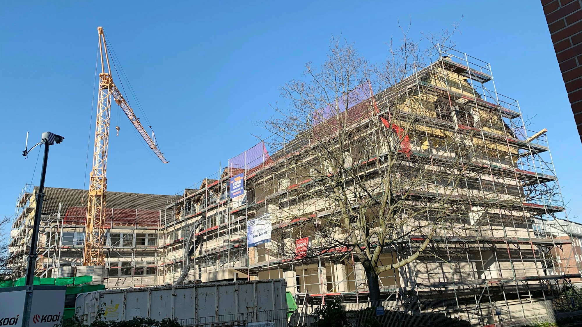 Das dreieinhalbgeschossige Gebäude in Euskirchen ist eingerüstet, auf dem Vorplatz steht ein Baukran.