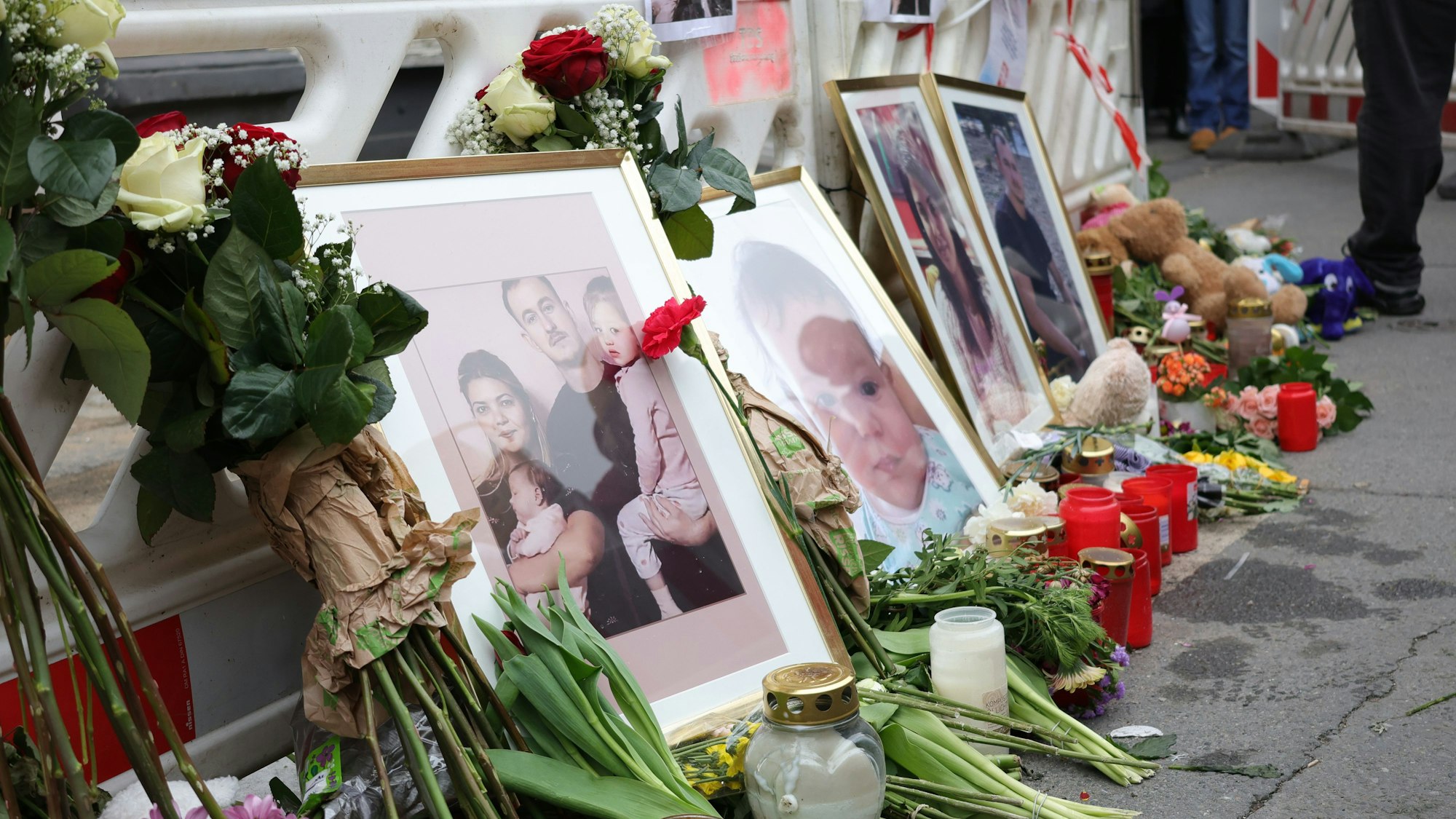 ARCHIV - 30.03.2024, Nordrhein-Westfalen, Solingen: Fotos einer aus Bulgarien stammenden Familie stehen bei einer Mahnwache vor dem ausgebrannten Haus. Fünf Tage nach der mutmaßlichen Brandstiftung in einem Wohnhaus in Solingen sind mehrere Hundert Menschen einem Trauermarsch für die vier Opfer gefolgt. (zu dpa: «Mörderische Feuer und Machetenangriff: Prozess startet») Foto: Gianni Gattus/dpa +++ dpa-Bildfunk +++