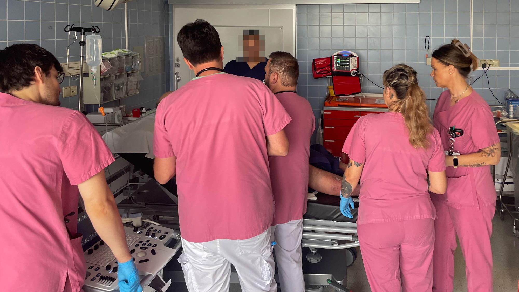 Mitarbeiter der Zentralen Notaufnahme des Marien-Hospitals in Euskirchen in rosafarbener Arbeitskleidung kümmern sich um einen Patienten.
