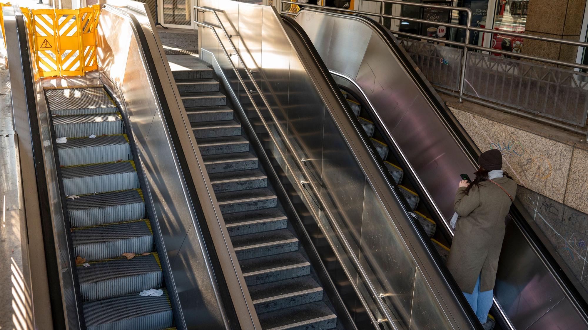 Zu sehen sind zwei Rolltreppen und eine Steintreppe am Friesenplatz. Eine Rolltreppe ist mit einem gelben Zaun abgesperrt.