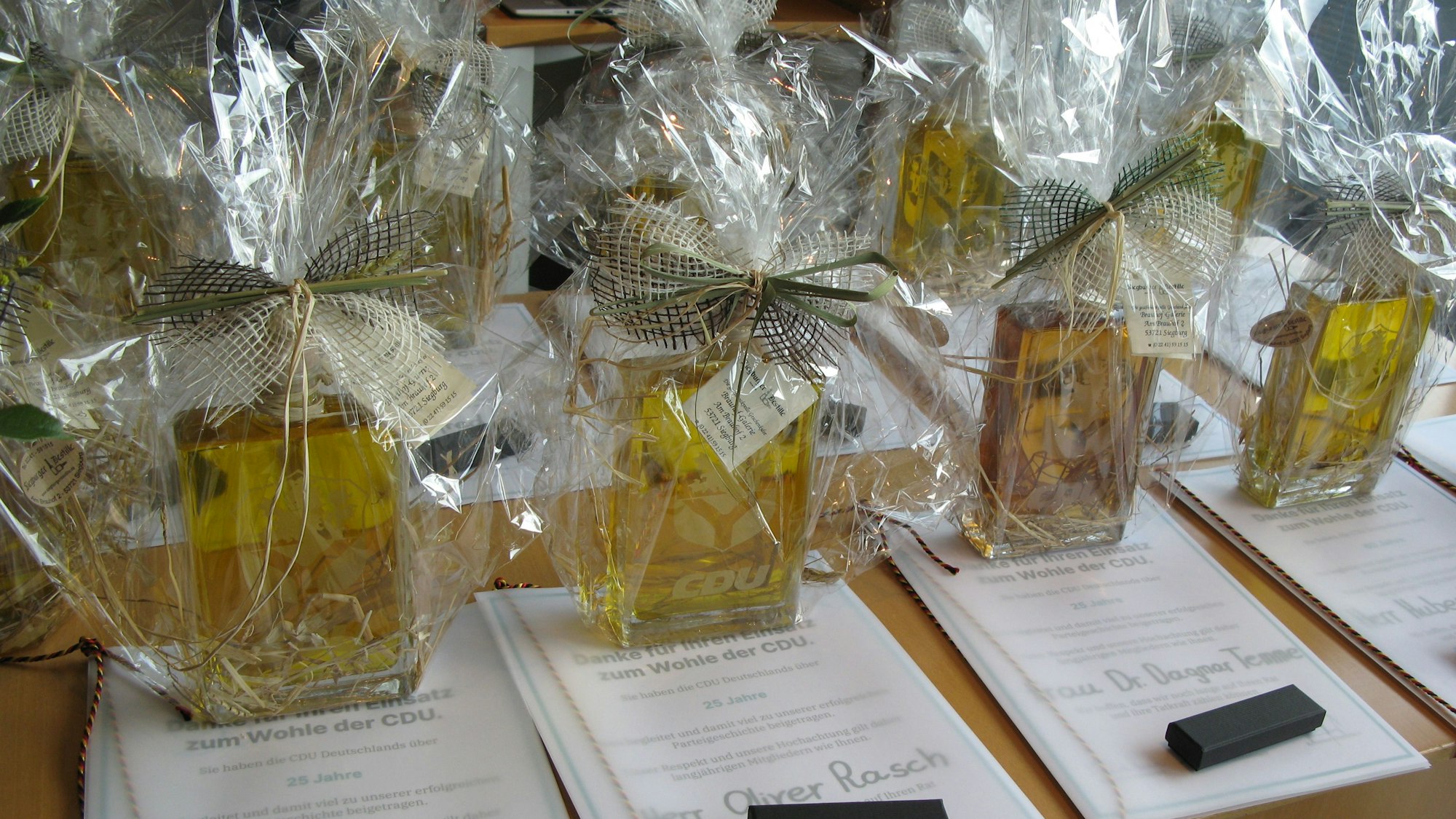 Urkunde und als Geschenk verpackte Likörflaschen.