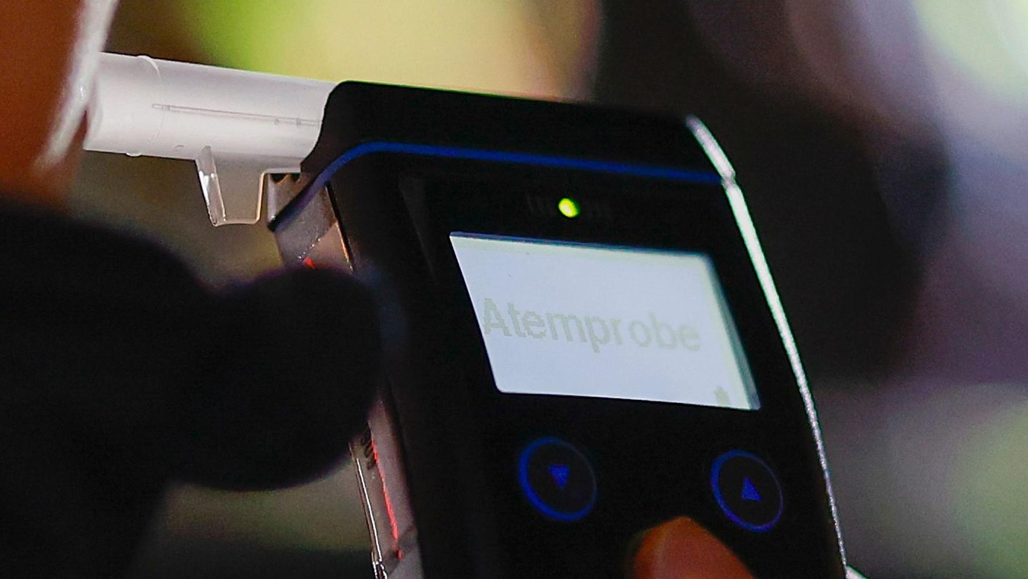 Die Polizei misst den Atemalkoholgehalt eines Autofahrers mit einem Alkoholtester.