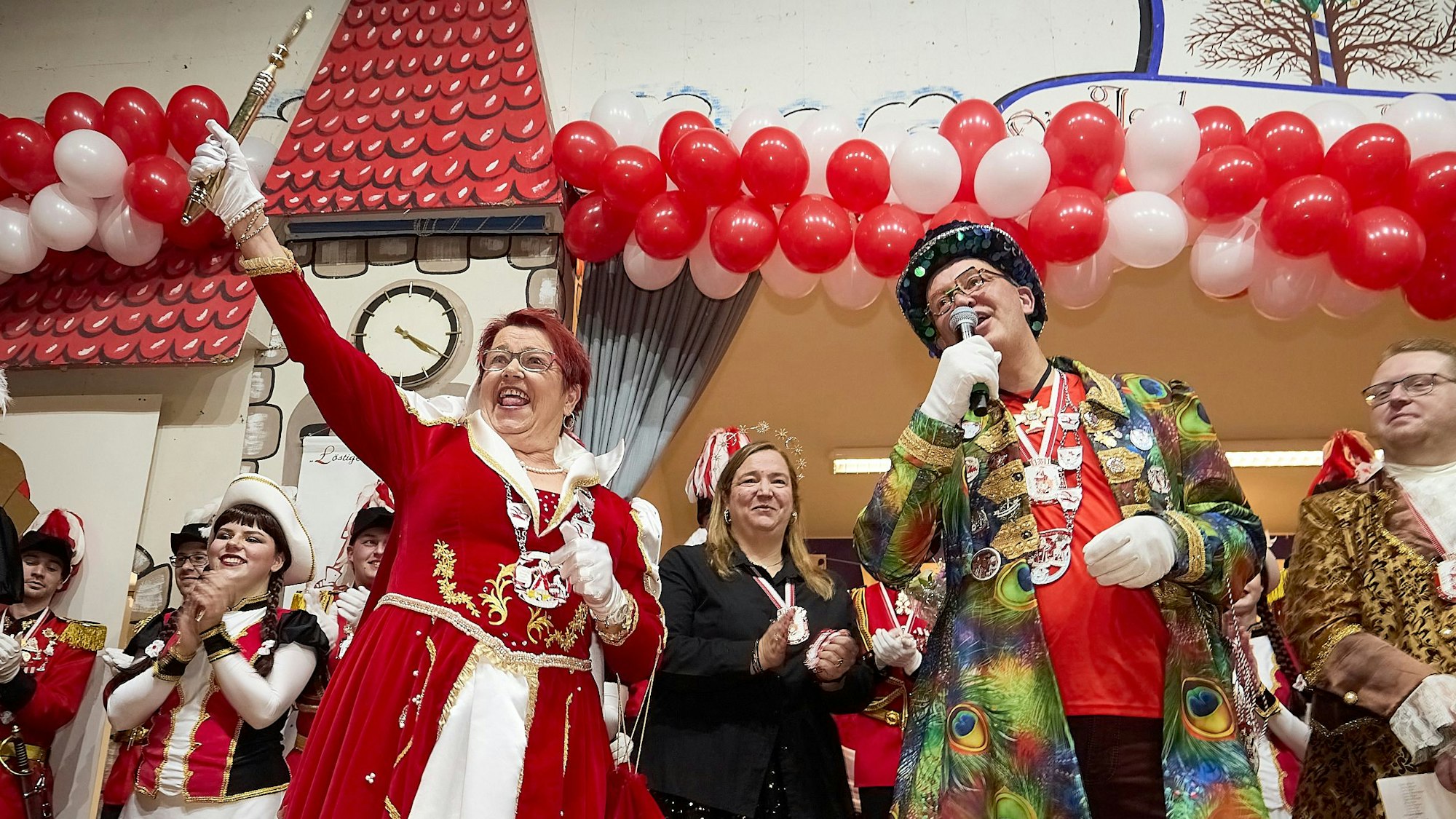 Prinzessin Uschi feiert zusammen mit anderen Karnevalisten auf der Bühne und reckt das goldene Zepter in die Luft.
