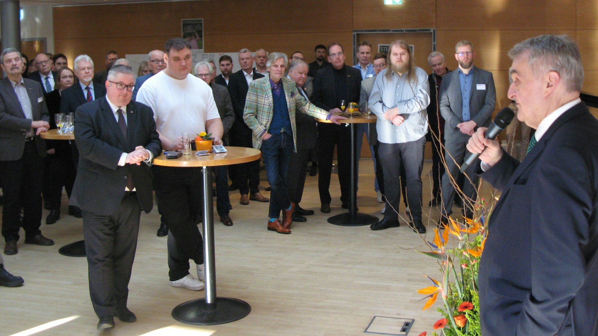 Innenminister Herbert Reul spricht vor einer Schar von Menschen in einem Saals ins Mikrofon.