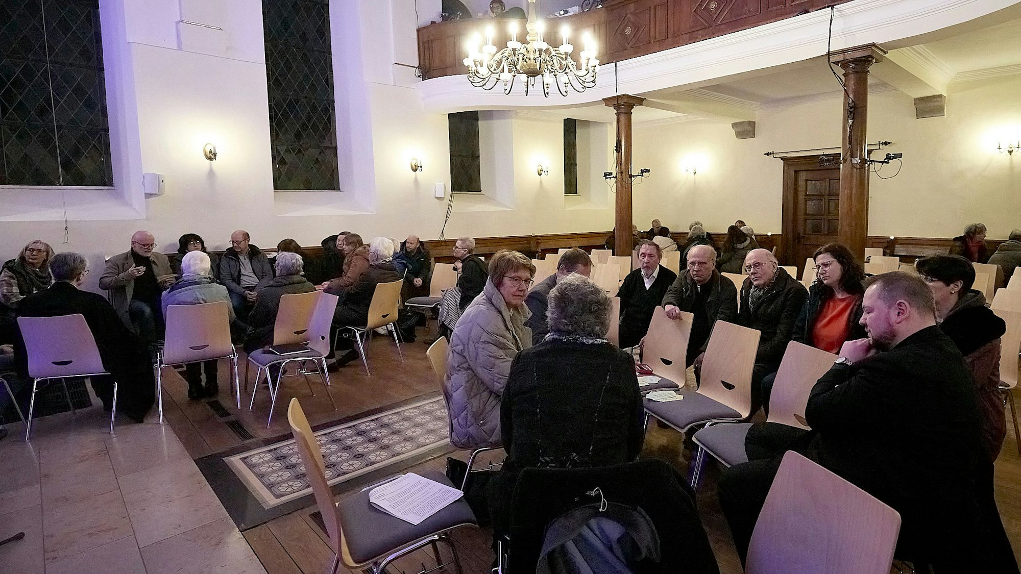 An den Tischen unterhalten sich die einzelnen Arbeitsgruppen.