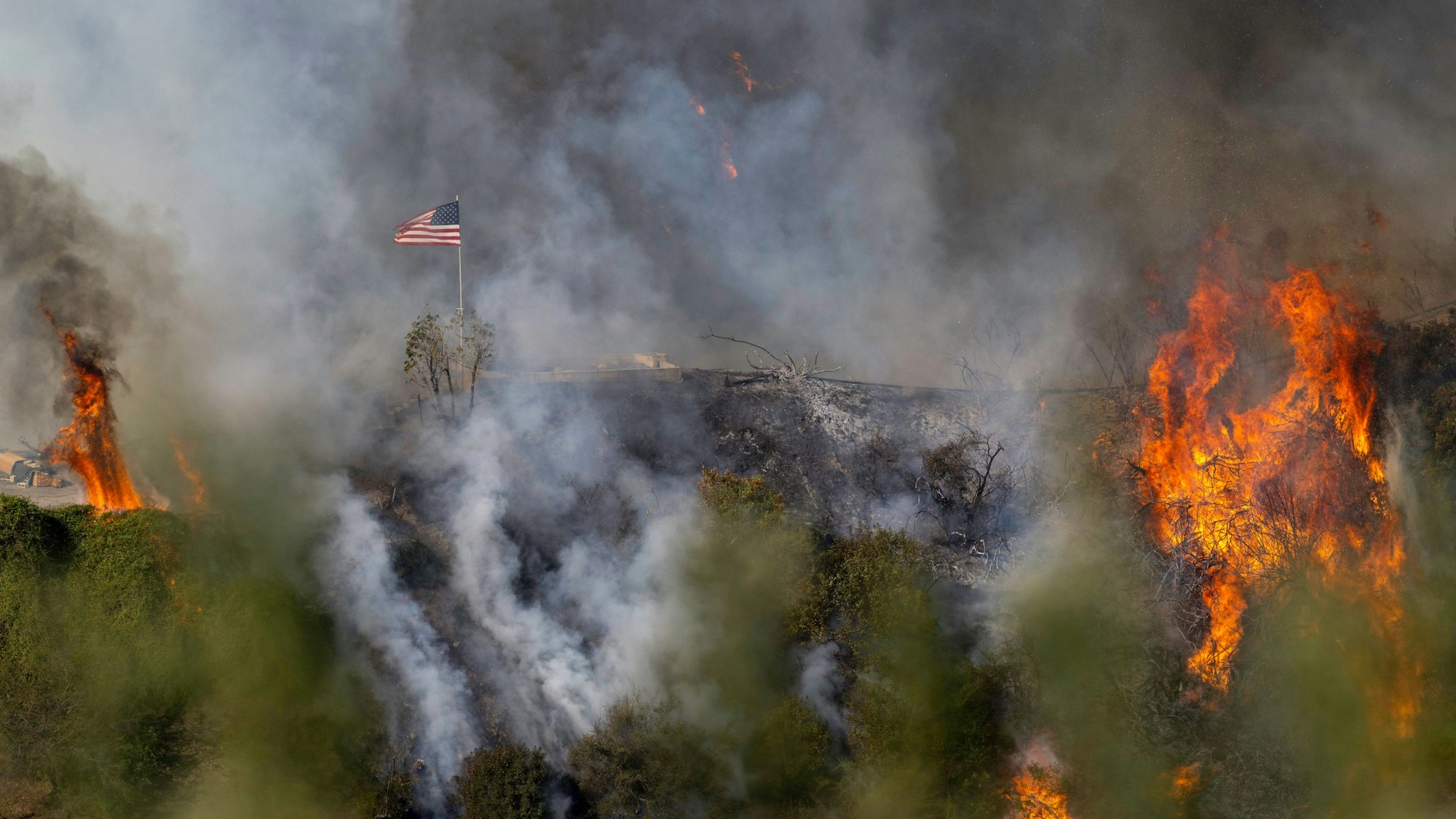 Los Angeles: Eine amerikanische Flagge weht über einem Teil des Mandeville Canyon, der durch das Palisades-Feuer zerstört wurde.