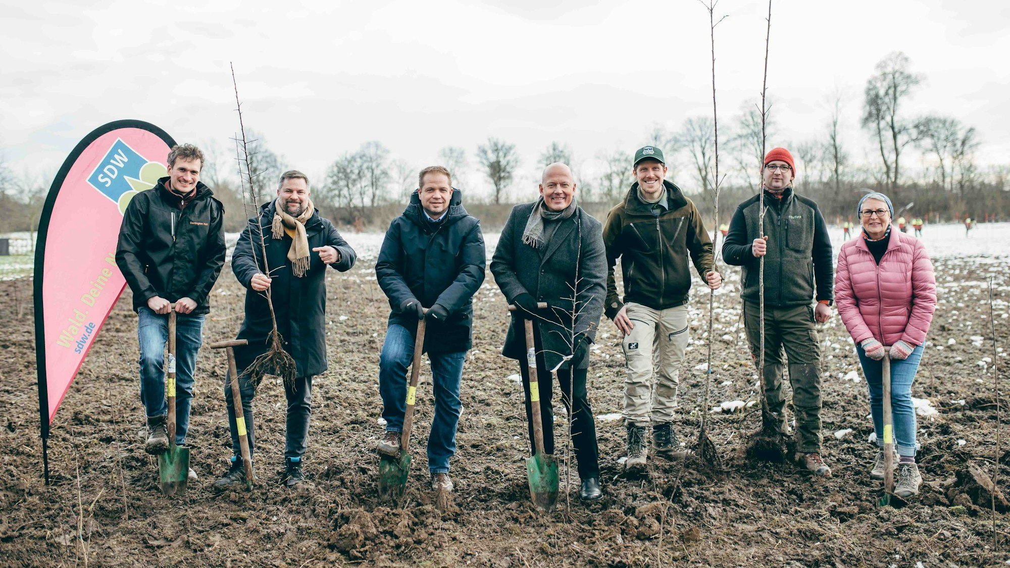 Das Foto zeigt mehrere Menschen beim Spatenstich für die Pflanzaktion von 4000 Bäumen.