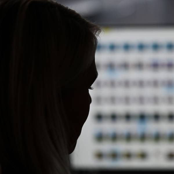 Eine Ermittlerin sitzt vor einem Monitor mit Kinderpornografie-Fotodateien.