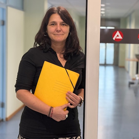 Anja Daub steht in einem Gebäude der Arbeitsagentur.