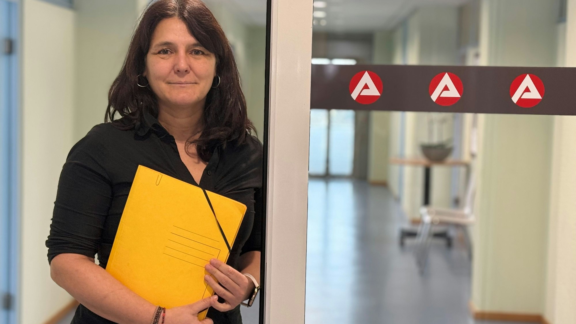 Anja Daub steht in einem Gebäude der Arbeitsagentur.