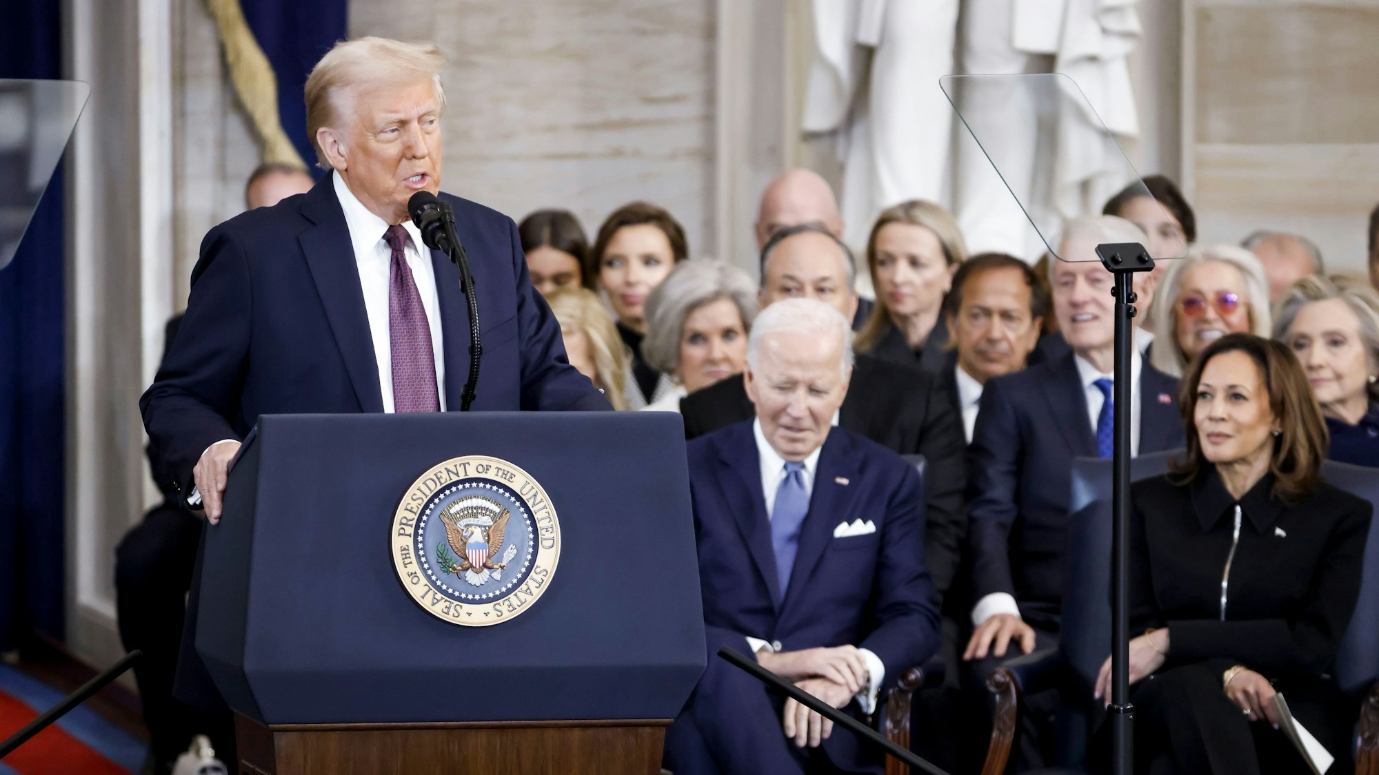Präsident Donald Trump (l.) spricht nach seiner Vereidigung zum Präsidenten der Vereinigten Staaten während der Amtseinführung des Präsidenten in der Rotunde des US-Kapitols in Washington, während der ehemalige Präsident Joe Biden (m.) und die ehemalige Vizepräsidentin Kamala Harris zusehen.