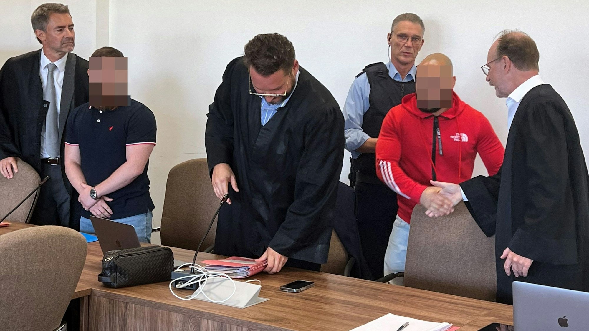 Die Angeklagten mit ihren Verteidigern beim Prozessauftakt im Kölner Landgericht.