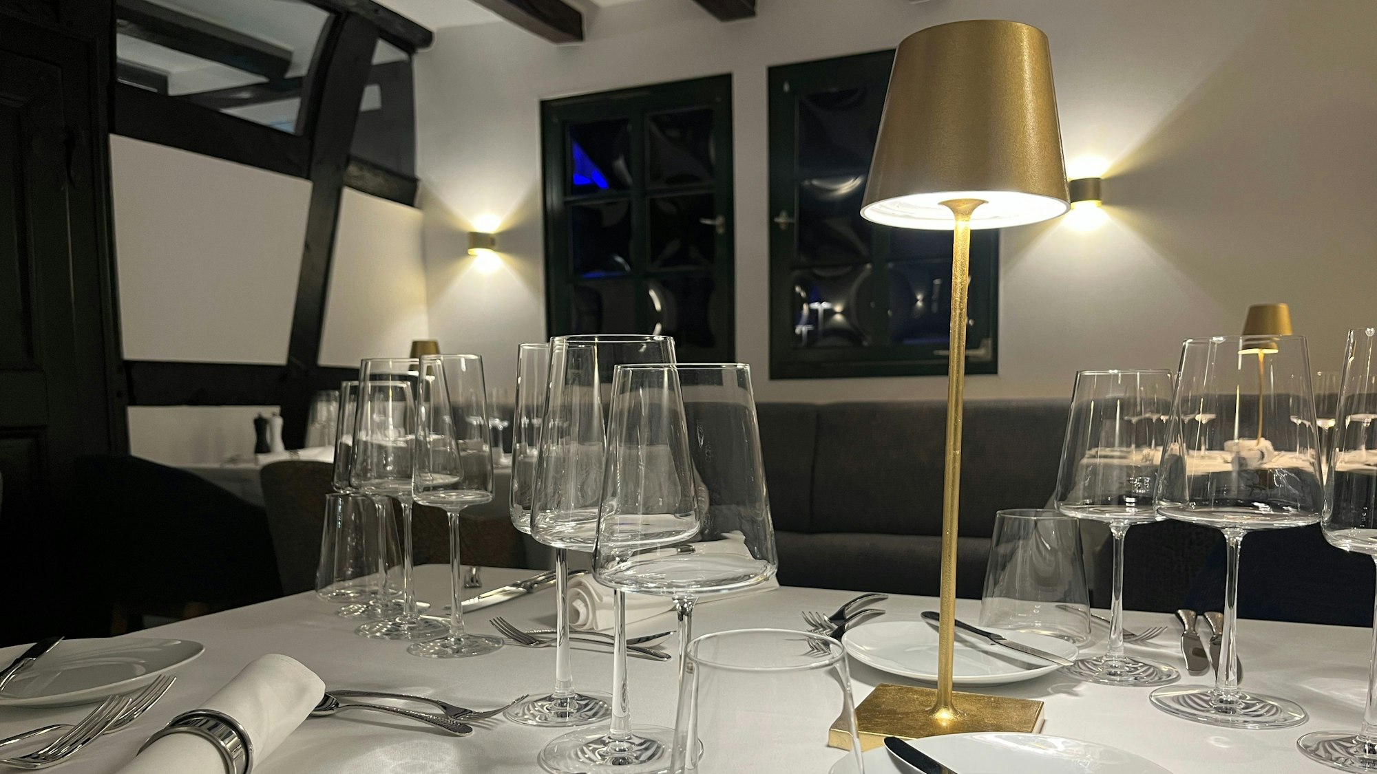 In einem Raum mit Fachwerkbalken sind Tische eingedeckt.