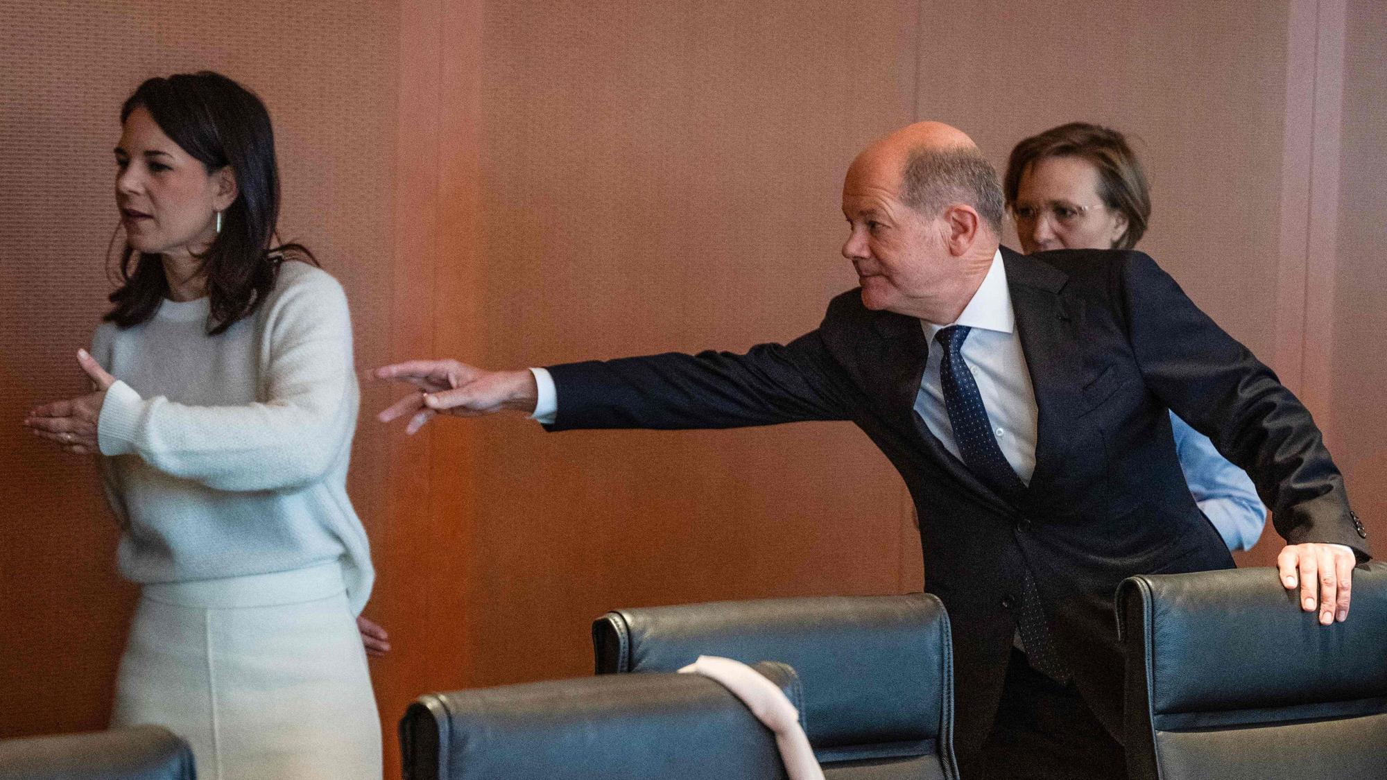 TOPSHOT - German Chancellor Olaf Scholz (R) reaches out for German Foreign Minister Annalena Baerbock at the start of the weekly cabinet meeting at the Chancellery in Berlin on January 15, 2025. (Photo by John MACDOUGALL / AFP)