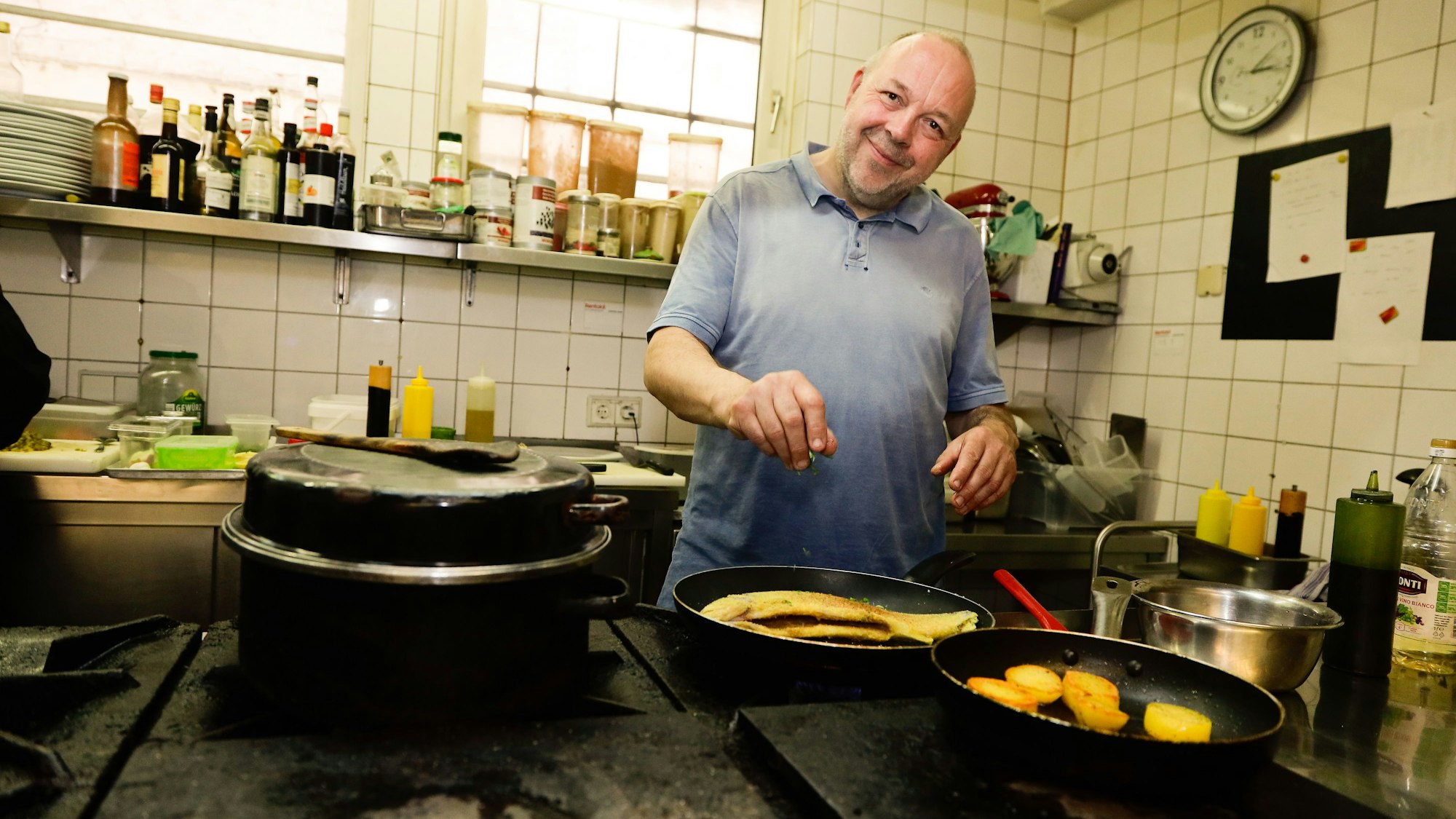 Inhaber und Koch Andreas Esser vom Gasthaus Essers in Köln steht hinterm Herd und stellt ein Menü vor.