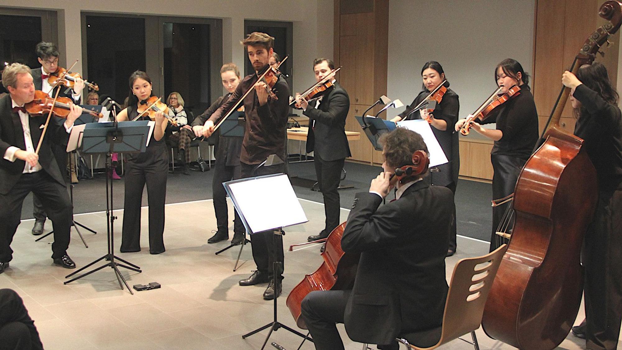 Im Ratssaal der Stadt Mechernich stehen und sitzen die Musiker der Mainzer Musici und spielen diverse Streichinstrumente.