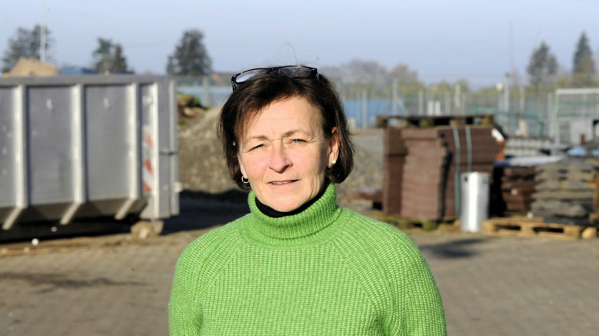 Zu sehen ist eine dunkelhaarige Frau in einem grünen Pullover.