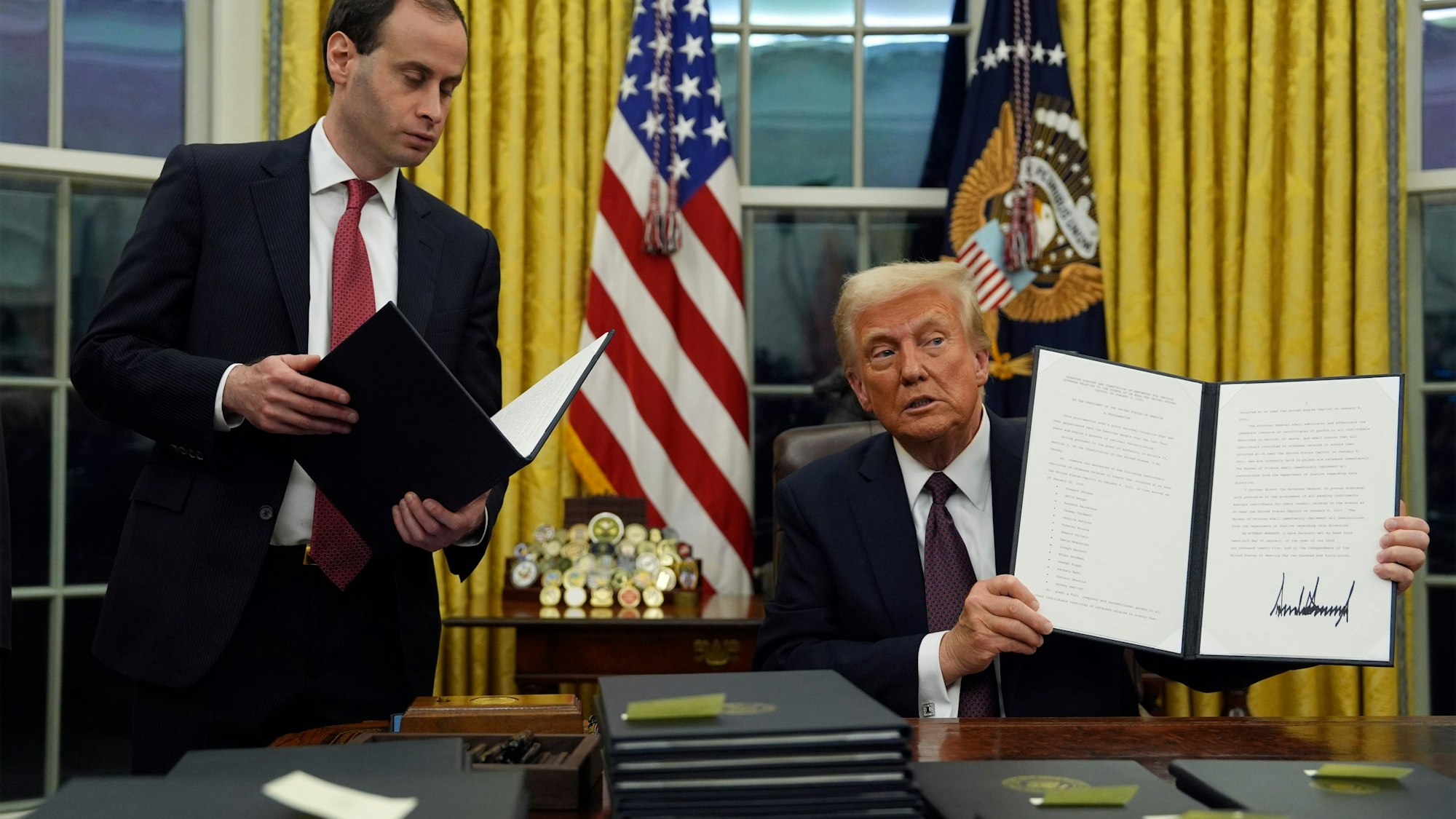 US-Präsident Donald Trump hält im Oval Office des Weißen Hauses eine Anordnung zur Begnadigung für Personen hoch, die im Zusammenhang mit der Kapitol-Attacke am 6. Januar 2021 verurteilt wurden.